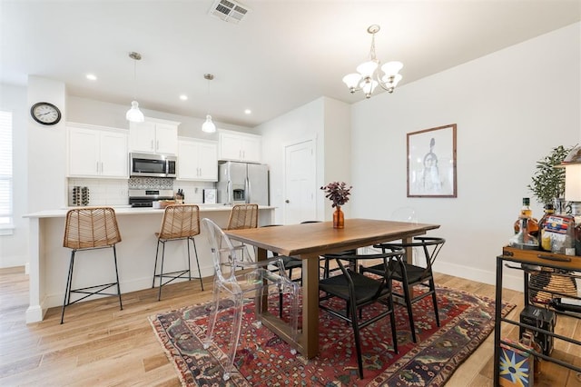 dining area featuring a chandelier and light wood-type flooring