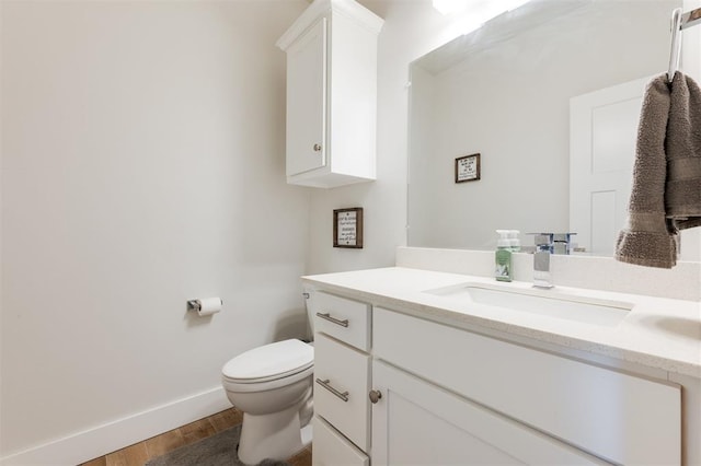 bathroom featuring vanity, hardwood / wood-style floors, and toilet