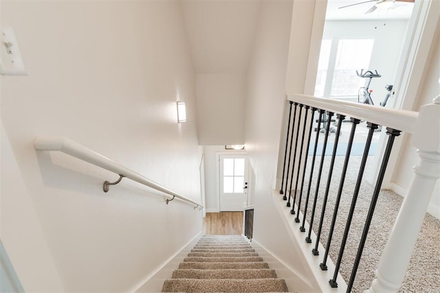 stairs featuring a towering ceiling and ceiling fan