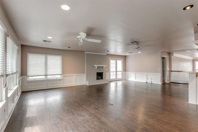 unfurnished living room featuring a fireplace, dark hardwood / wood-style floors, and ceiling fan