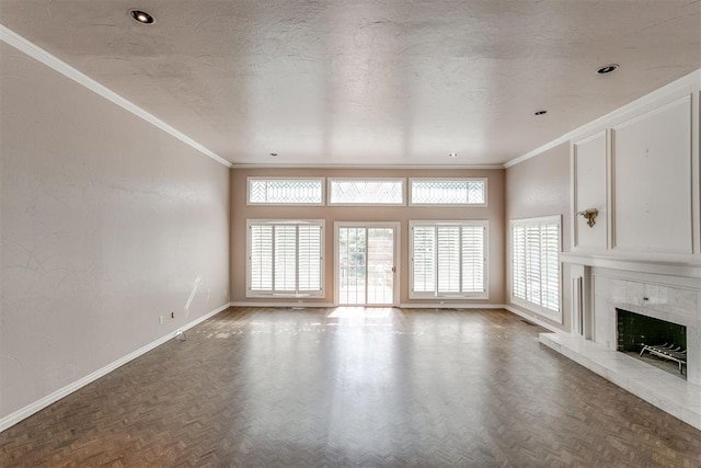 unfurnished living room featuring a tile fireplace, ornamental molding, parquet floors, and a textured ceiling