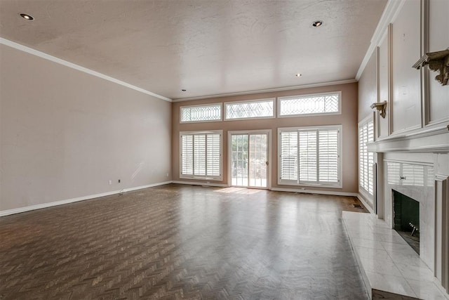 unfurnished living room featuring parquet flooring, ornamental molding, a premium fireplace, and a textured ceiling