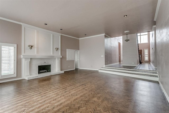 unfurnished living room featuring crown molding, parquet flooring, and a wealth of natural light