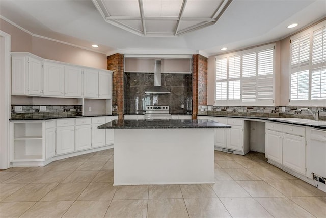 kitchen with white cabinetry, a center island, wall chimney range hood, and electric range