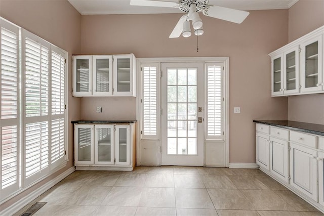 doorway with light tile patterned flooring and ceiling fan