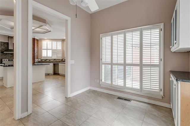 unfurnished dining area featuring light tile patterned flooring and ceiling fan