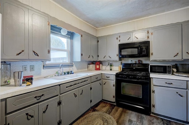 kitchen with sink, gray cabinetry, dark hardwood / wood-style floors, and black appliances