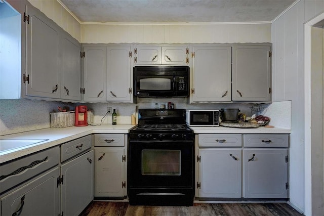 kitchen with sink, gray cabinets, dark hardwood / wood-style floors, ornamental molding, and black appliances