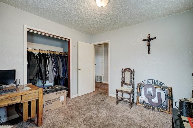 carpeted bedroom featuring a textured ceiling and a closet