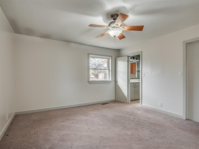 unfurnished bedroom with connected bathroom, light colored carpet, and ceiling fan