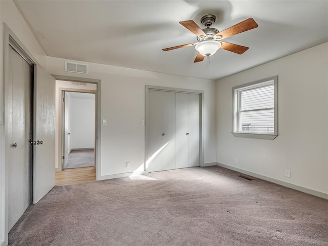 unfurnished bedroom with ceiling fan, a closet, and light carpet