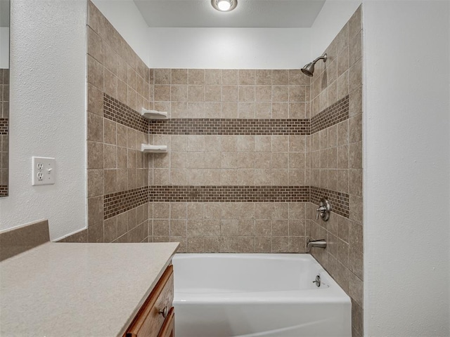 bathroom with vanity and tiled shower / bath