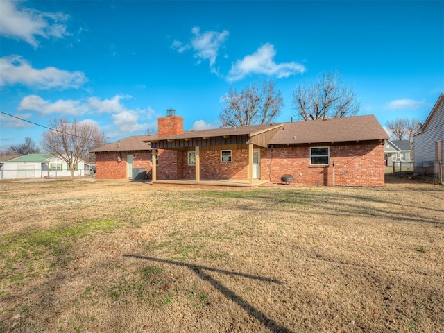 back of property featuring a lawn and a patio