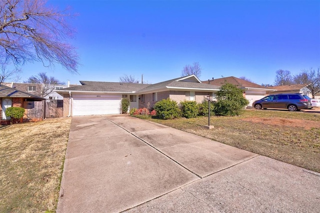 ranch-style house featuring a garage and a front lawn