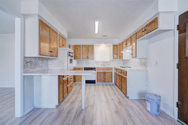 kitchen with sink, backsplash, white appliances, and light hardwood / wood-style floors