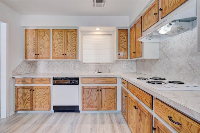 kitchen with decorative backsplash, white appliances, sink, and light hardwood / wood-style flooring