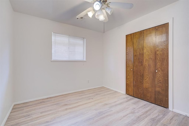 unfurnished bedroom featuring ceiling fan, light hardwood / wood-style floors, and a closet