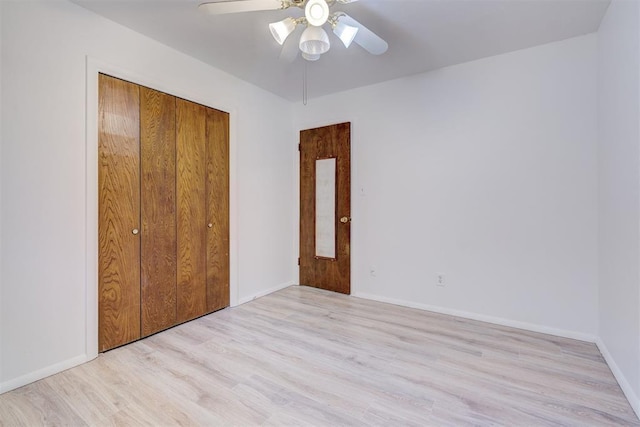 unfurnished bedroom featuring ceiling fan, light hardwood / wood-style floors, and a closet