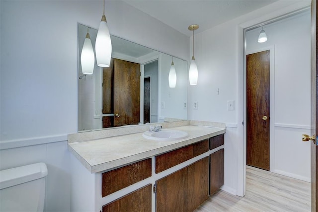 bathroom with vanity, toilet, and hardwood / wood-style floors