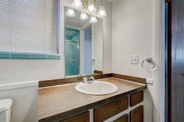 bathroom featuring vanity, walk in shower, and toilet