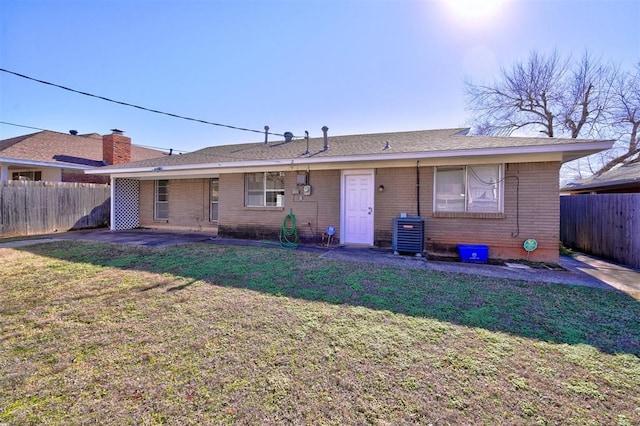 back of house featuring cooling unit, a patio area, and a lawn