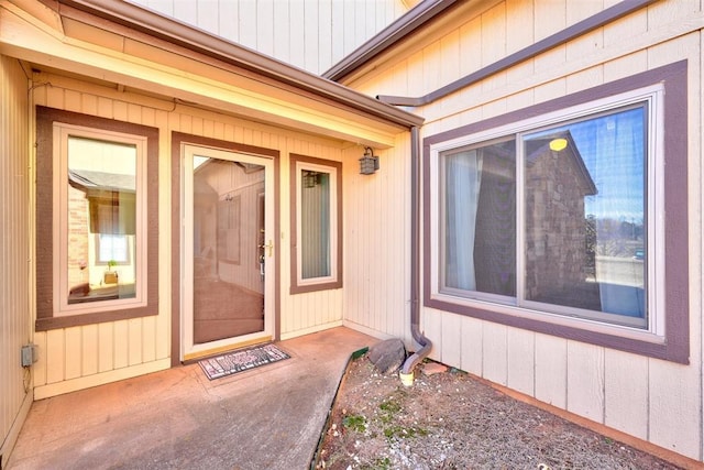 view of exterior entry with a patio