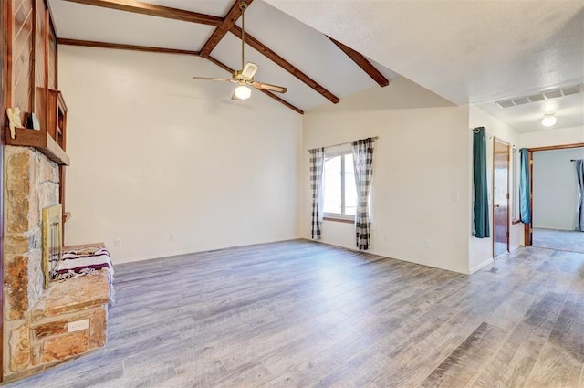 unfurnished living room with ceiling fan, light hardwood / wood-style flooring, and vaulted ceiling with beams