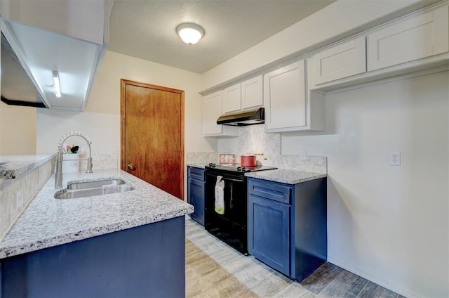 kitchen with black electric range oven, sink, white cabinets, blue cabinets, and light wood-type flooring