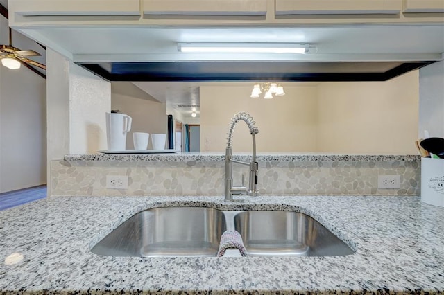 details with tasteful backsplash, light stone countertops, and sink