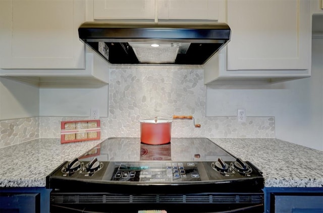 kitchen featuring white cabinetry, blue cabinets, range hood, and light stone countertops