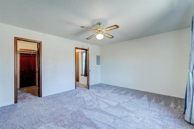 unfurnished bedroom featuring carpet flooring, a spacious closet, a closet, and a textured ceiling