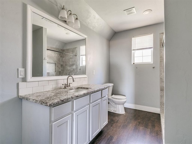 bathroom featuring tasteful backsplash, hardwood / wood-style floors, a wealth of natural light, and lofted ceiling