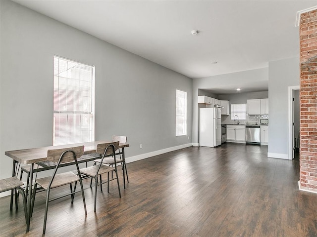 dining space with dark hardwood / wood-style flooring and sink