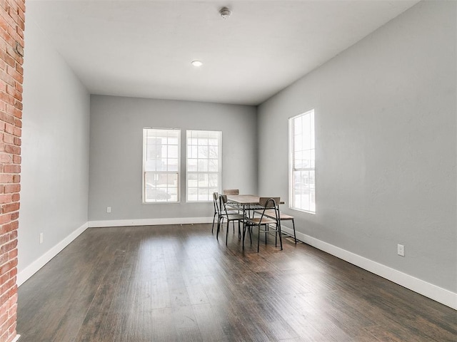 unfurnished dining area with dark wood-type flooring