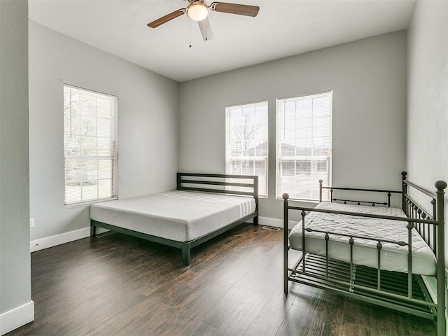 bedroom with dark hardwood / wood-style floors and ceiling fan