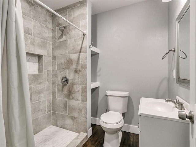 bathroom with hardwood / wood-style flooring, vanity, curtained shower, and toilet