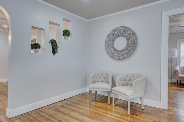 living area with ornamental molding and light hardwood / wood-style floors