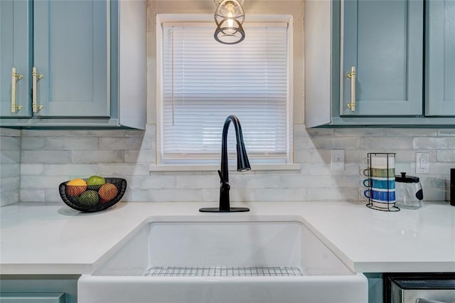 details featuring sink, decorative backsplash, and blue cabinets