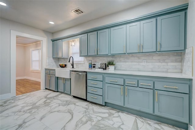 kitchen with sink, decorative backsplash, dishwasher, and blue cabinets