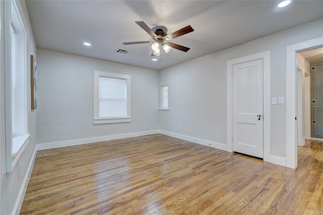 empty room with ceiling fan and light hardwood / wood-style floors