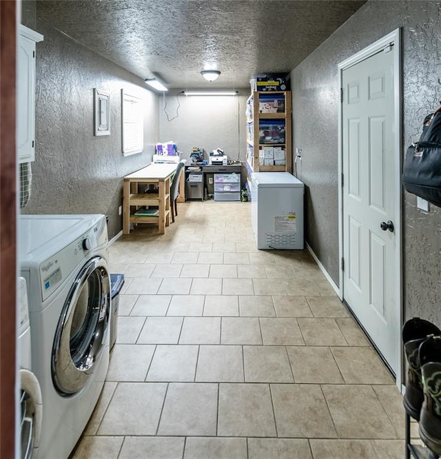 clothes washing area featuring separate washer and dryer, light tile patterned floors, and a textured ceiling