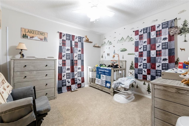 carpeted bedroom with ceiling fan and a textured ceiling