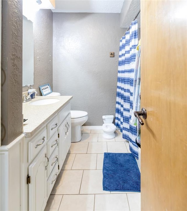 bathroom with vanity, tile patterned floors, and toilet