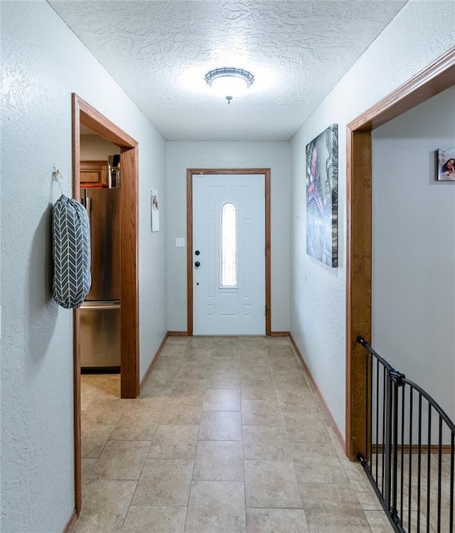 foyer entrance featuring light tile patterned flooring and a textured ceiling