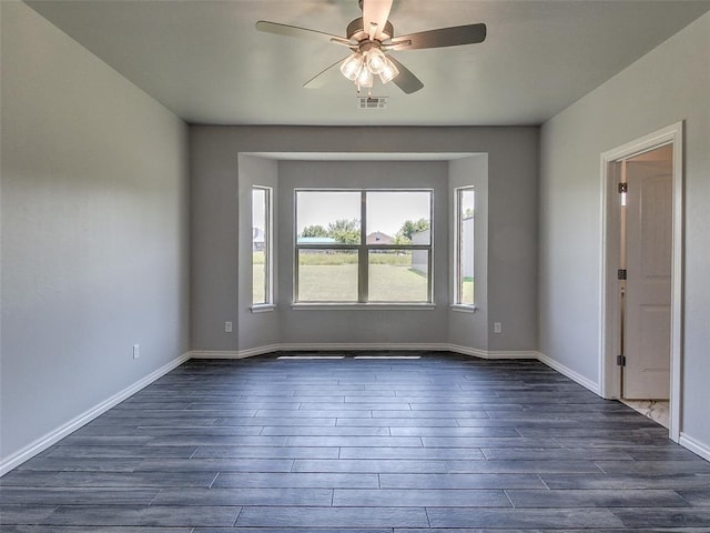 spare room with dark wood-type flooring and ceiling fan