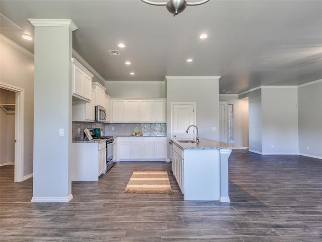 kitchen with sink, a center island with sink, appliances with stainless steel finishes, light stone countertops, and white cabinets