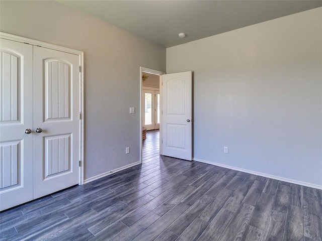 unfurnished bedroom with dark wood-type flooring and a closet