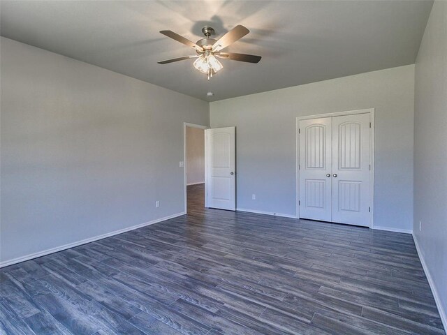 unfurnished bedroom featuring dark hardwood / wood-style flooring, a closet, and ceiling fan