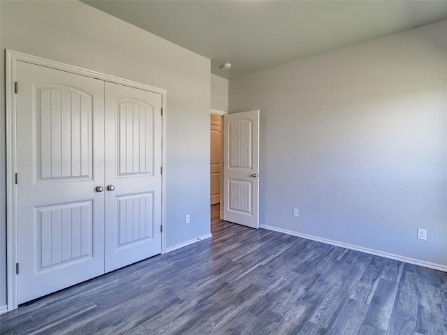 unfurnished bedroom featuring dark hardwood / wood-style floors and a closet