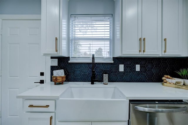 kitchen featuring tasteful backsplash, stainless steel dishwasher, and white cabinets